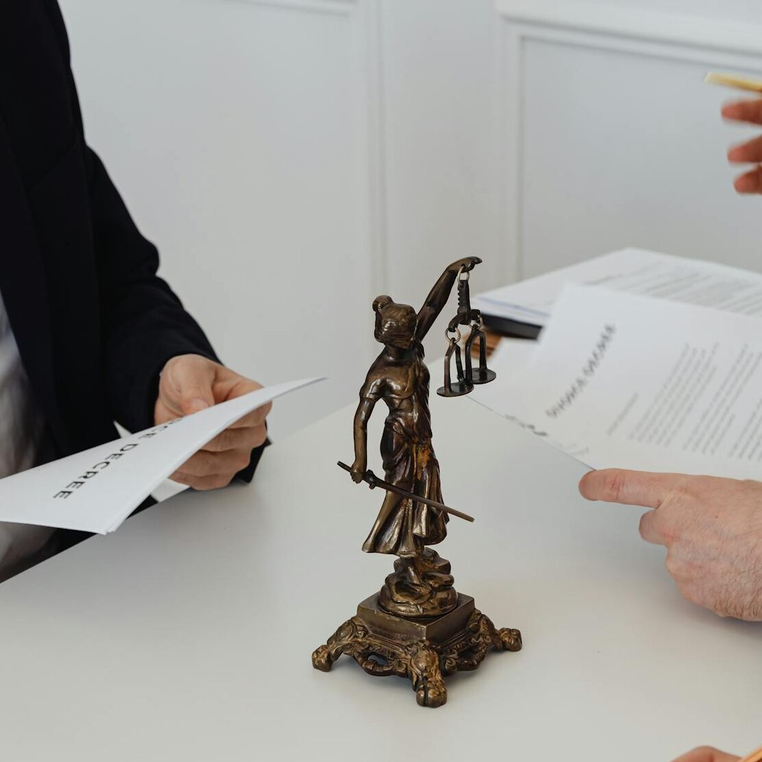 Three professionals reviewing divorce papers in a law office setting.